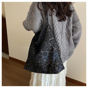 Close-up of leopard print tote bag being worn over the shoulder with casual knitwear