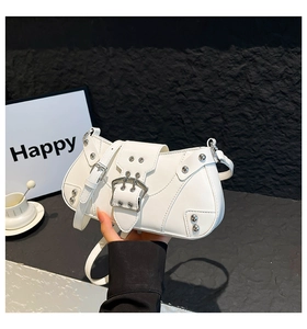 Détail du sac sous le bras en cuir blanc avec grande boucle en métal et rivets