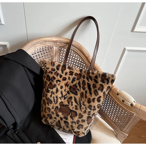 Dettaglio della borsa tote leopardata in ecopelliccia con manici marroni su sedia vintage
