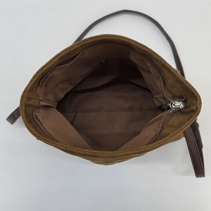 Interior view of brown suede crossbody bag showing the main compartment and zipper pocket