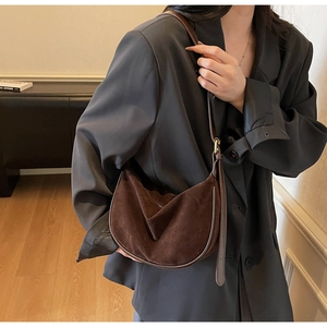 Detail of dark brown suede hobo bag showing its textured material and retro folds