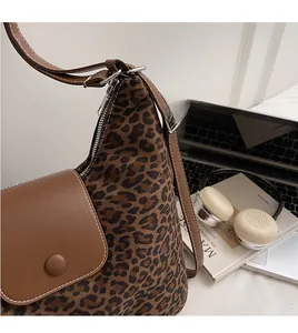 Detail of leopard print tote bag with brown leather flap and adjustable silver buckle