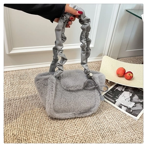 Detail of grey plush faux fur handbag with stylish ruched handle and side bow accent