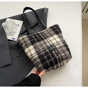 Dettaglio della borsa a secchiello in tweed a scacchi con cinturini in pelle