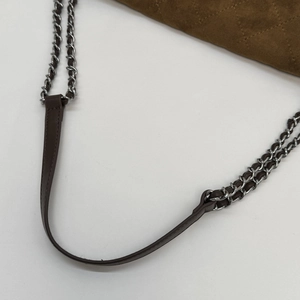 Detail of brown suede shoulder bag with quilted rhombic pattern and chain strap
