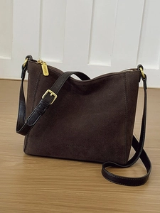 Large dark brown suede bucket bag with leather shoulder strap and gold metal buckle