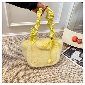 Detail of soft yellow faux fur handbag with stylish pleated cloud handles and ribbon bow