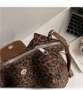 Detail of leopard print tote bag showing smooth metal zipper and secure magnetic closure