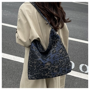 Deep blue leopard print tote bag styled with a khaki trench coat in a street setting