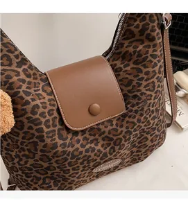 Close-up of leopard print tote bag fabric with leather strap and silver metal zipper