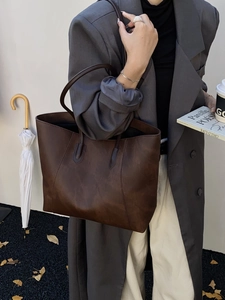 Detail of vintage dark brown faux leather tote bag with smooth texture for women