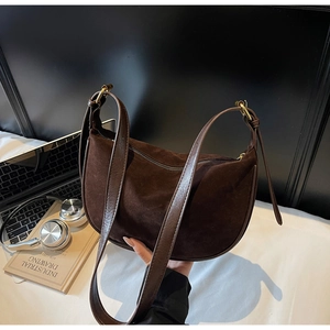 Detail view of premium dark brown suede hobo bag with vintage gold buckle and leather strap