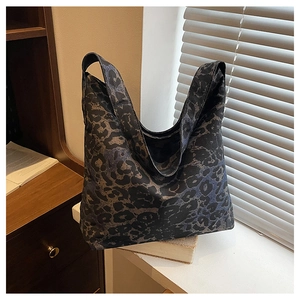 Detailed view of the large leopard print tote bag placed on vintage books in a room