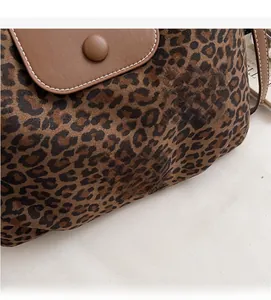 Close-up of leopard print tote bag with brown leather flap and magnetic snap button