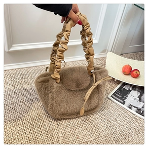 Close-up of khaki faux fur tote bag featuring ruffled leather handle and soft texture