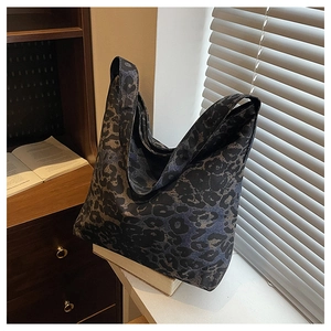 Detailed view of leopard print tote bag placed on a desk by the window with soft lighting