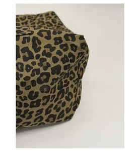 Close-up of reinforced bottom corner showing durable stitching on leopard print canvas tote