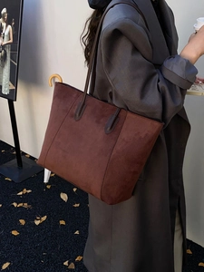 Close-up of a deep brown faux suede tote bag shown on model for autumn winter style