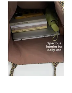 Detailed top view of a large leopard print tote bag interior with books and a laptop