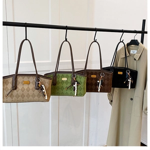 Detail of vintage quilted tote bag with golden logo and decorative bead charm detail