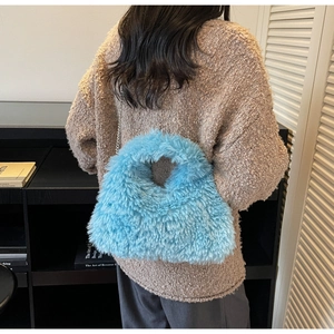 Makroaufnahme einer hellblauen Kunstfell-Tasche mit elegantem silbernen Ketten-Schultergurt