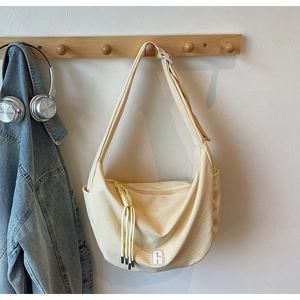 Detail of light yellow checkerboard hobo bag with R logo and woven zipper puller