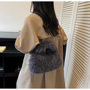 Detail der dunkelgrauen Lammfell-Tasche mit flauschiger Textur und Metallkettenriemen