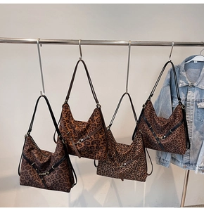 Detail view of four large leopard print hobo bags with black leather straps and metal hardware