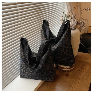 Detail shot of leopard print tote bag on a wooden table with soft lighting