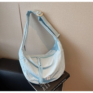 Detailed texture of light blue waffle fabric crescent bag with white R logo detail