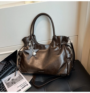 Nahaufnahme braune Vintage-Tote-Bag mit Sternanhänger und elegantem Metallschloss-Detail