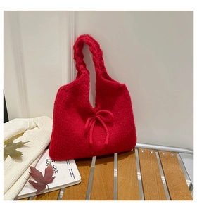 Detailed close-up of a red knit handbag with a bow knot design and soft texture