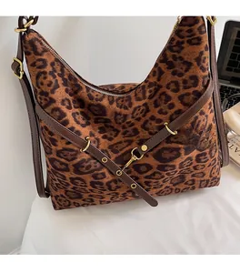 Close-up of leopard print shoulder bag with textured velvet finish and golden buckle