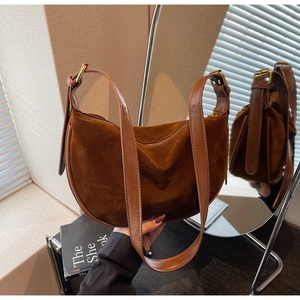 Deep brown suede crescent bag with smooth leather strap and elegant gold hardware