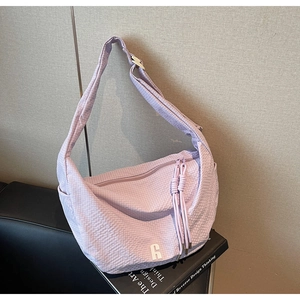 Detail of lavender hobo bag featuring textured seersucker fabric and a silver logo