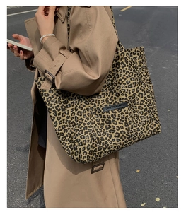 Macro detail of leopard print canvas tote bag with Own The Moment rectangular rubber patch