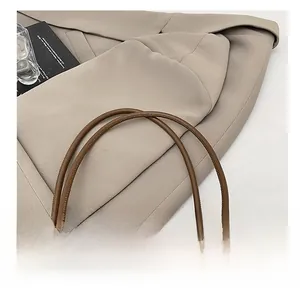 Close-up of a premium brown leather shoulder strap with reinforced stitching details