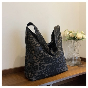 Detailed view of leopard print tote bag on a wooden table with elegant floral background