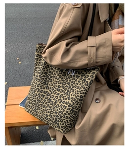 Close-up of leopard print tote bag fabric with subtle text detail for autumn fashion