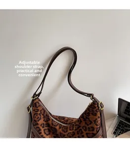 Detail of adjustable leather strap and golden hardware on leopard print hobo bag