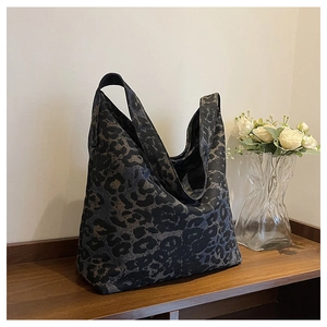 Close-up of leopard print tote bag on a wooden shelf with minimalist home decor