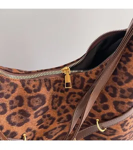 Detailed close-up of smooth golden metal zipper and leopard print suede fabric texture