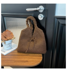 Close-up of dark brown knit tote bag with bow detail and textured wool weave