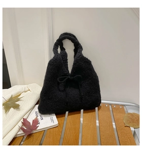 Detailed knit texture and bow knot design of a chic black handmade woven tote handbag