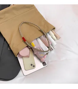 Interior storage view of khaki tote bag holding tablet, umbrella and cosmetics