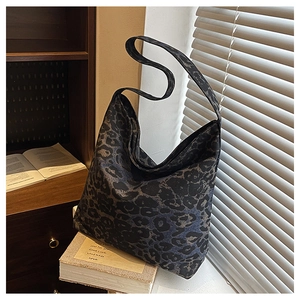 Detailed view of large leopard print tote bag with thick strap in a cozy interior setting