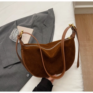 Detail of dark brown suede crescent hobo bag with adjustable smooth leather strap