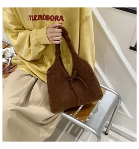 Detail of coffee brown knit handbag with thick yarn texture and elegant bow design