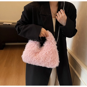 Rosa Plüsch-Handtasche in Halbmondform kombiniert mit schwarzem Blazer für den Winter