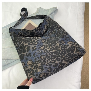 Macro shot of large leopard print tote bag fabric and wide shoulder strap detail